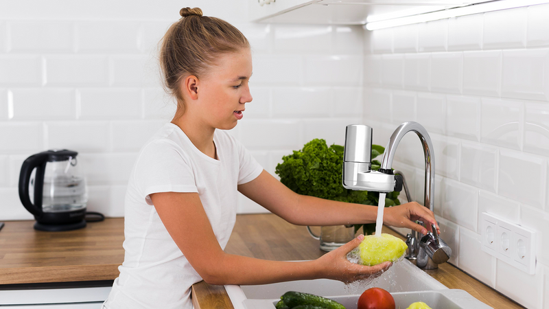 Young girl washing produce with clean water from a Brita Faucet Filtration System using Fil-Fresh filter replacements