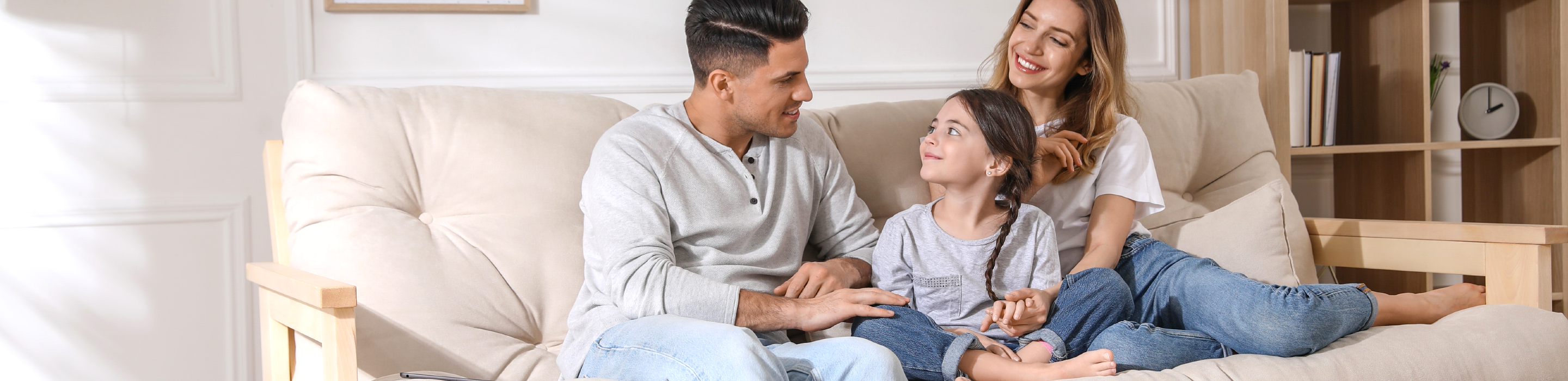 Happy family laughing and chatting together on the couch, enjoying a cozy home environment with Fil-Fresh filtration