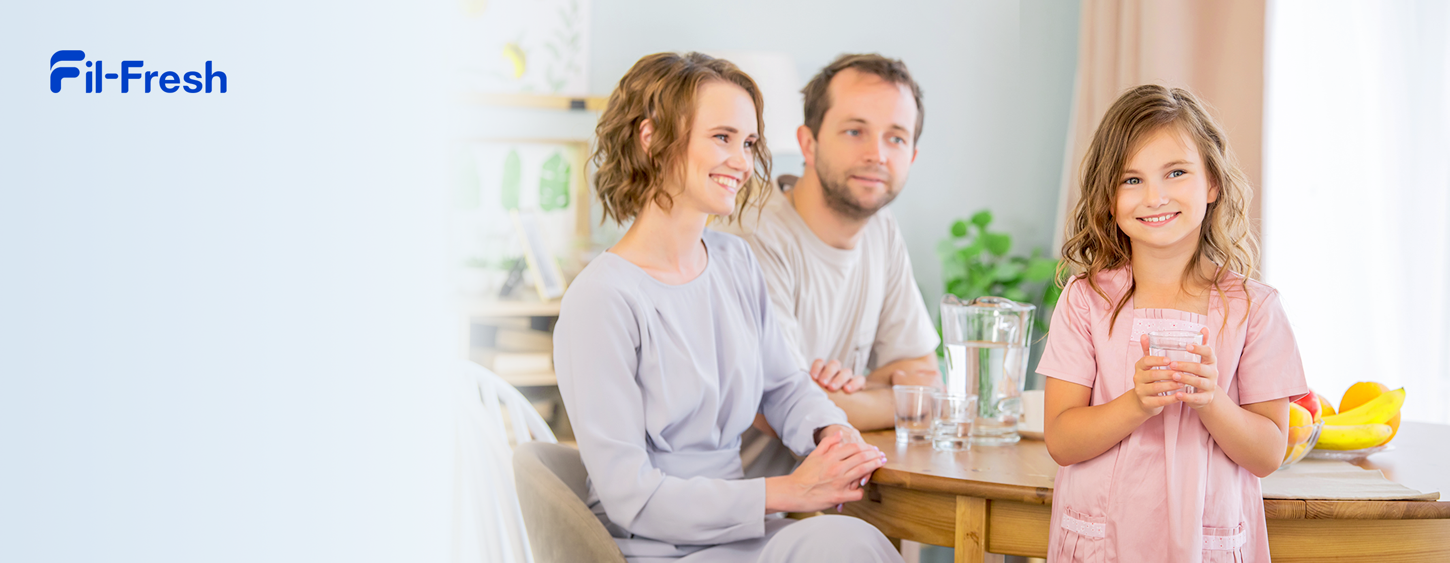 Happy family moment at the dining table with daughter enjoying a glass of filtered water