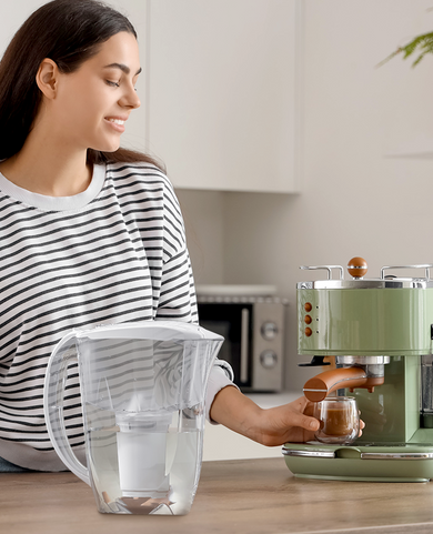 Young woman making coffee with an espresso machine using filtered water to help reduce limescale