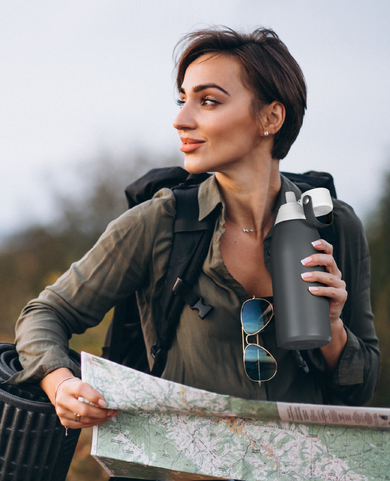 Hiker with camping gear and a map, drinking from a water bottle using Fil-Fresh replacement filter