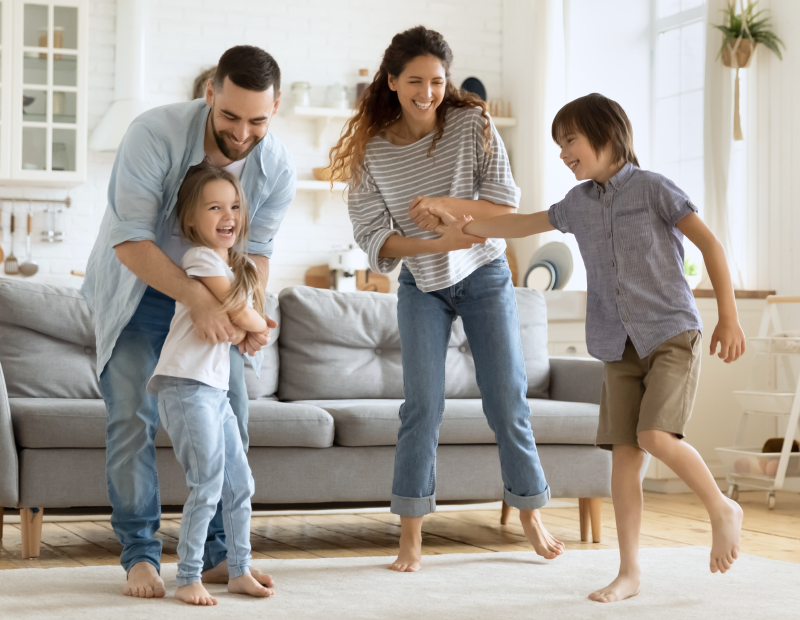 Happy family of four spending quality time together in a cozy living room with Fil-Fresh air filter improving air quality