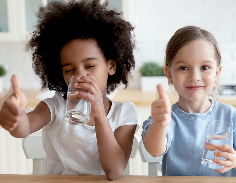 Two little girls giving a thumbs-up while drinking water filtered by Fil-Fresh pitcher water filter