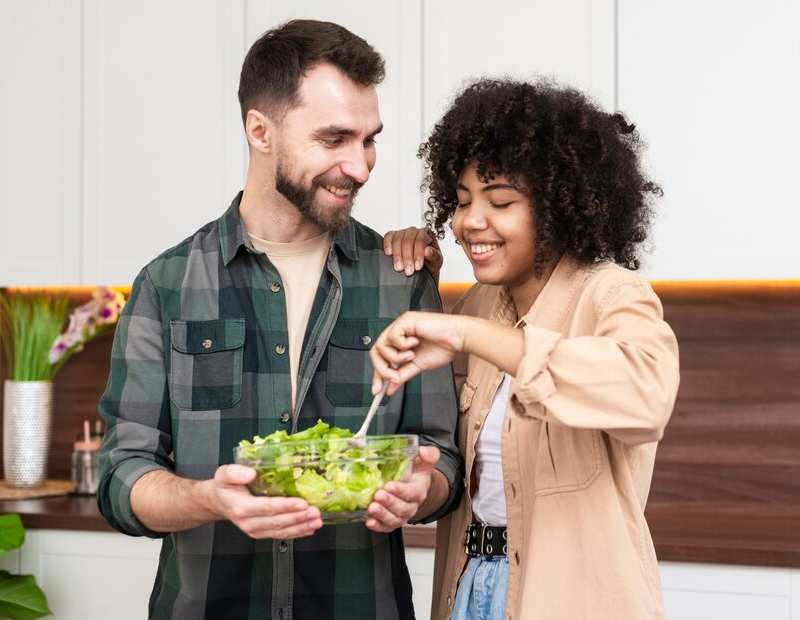 Smiling couple savoring a fresh salad with veggies rinsed using Fil-Fresh faucet water filter replacement