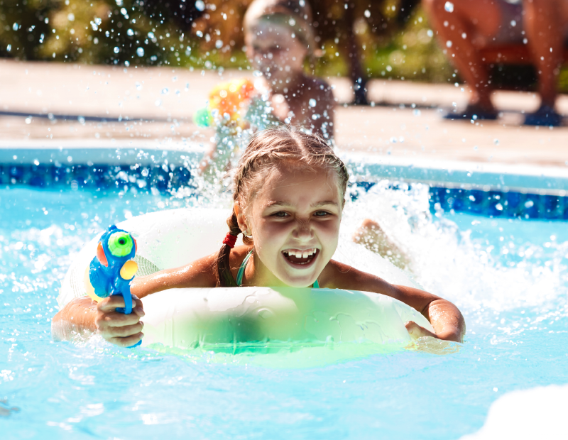 Little girl happily playing in the pool enjoying clean, clear water filtered by Fil-Fresh pool filter cartridges